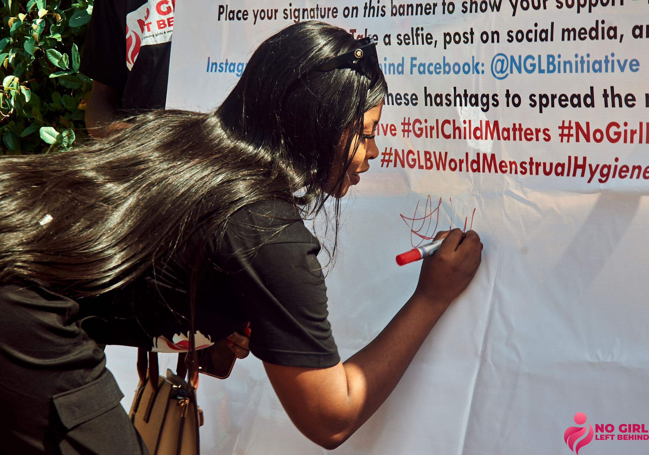 Women signing campaign banner